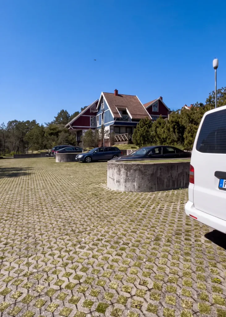 Namas ir automobilių stovėjimo aikštelė saulėtą dieną