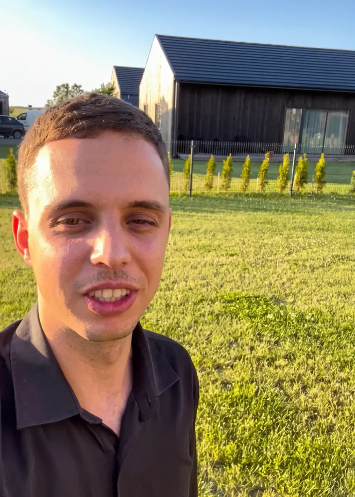 Paulius Nečiūnas lauke prie modernaus namo