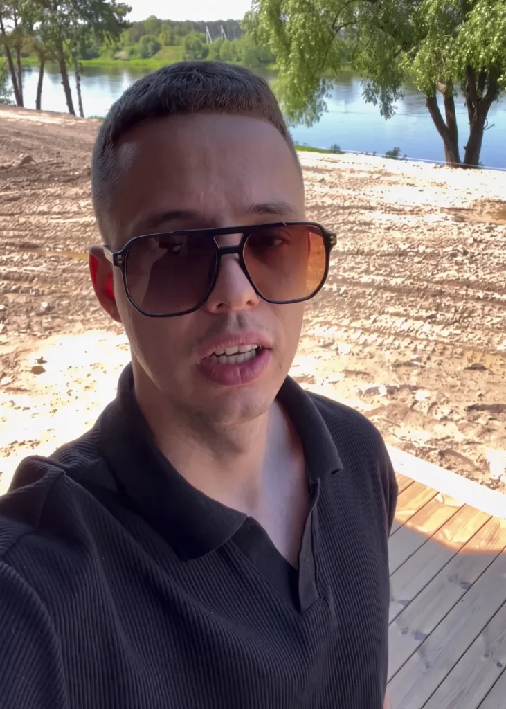 Paulius Nečiūnas prie ežero su akiniais nuo saulės